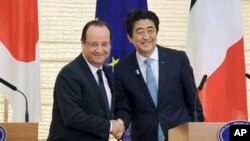 Presiden Perancis Francois Hollande (kiri) dan PM Jepang Shinzo Abe berjabat tangan seusai jumpa pers di rumah dinas PM Abe di Tokyo (7/6).