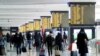 People walk carrying their luggage past train schedule displays at Termini train station, on the day the government lays out a plan of coronavirus disease (COVID-19) restrictions over the Christmas period, in Rome, Dec. 19, 2020. 