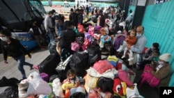 Migrantes venezolanos esperan un autobús para viajar a la frontera, luego de levantar su campamento en Bogotá, Colombia, el jueves 2 de julio de 2020. 