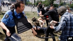 A policemen clashes with an opponent of a gay rights march, in Kiev, Ukraine, June 6, 2015. 