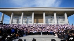 4일 한국 국회의사당에서 야당 국회의원들이 윤석열 대통령 탄핵에 관련된 집회를 벌이고 있다.