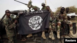 Les soldats ont pris le drapeau de Boko Haram pris dans la ville de Damasak, au Nigeria, le 18 mars 2015. 