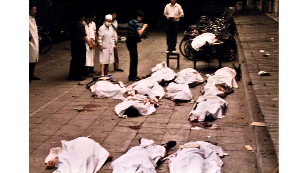 FILE - Medical workers of Beijing's Fuxingmen Hospital look at bodies of protesters killed by soldiers near Tiananmen Square on June 4, 1989.