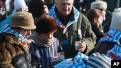 Holocaust survivors light candles at the International Monument to the Victims of Fascism, after a ceremony marking the 72nd anniversary of the liberation of the German Nazi death camp Auschwitz-Birkenau, in Oswiecim, Poland, Jan. 27, 2017, on Internation