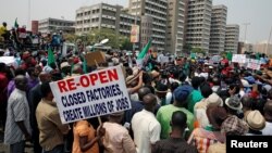 Anti-government protesters hold flags as they march in Abuja, Nigeria, Feb. 9, 2017. 