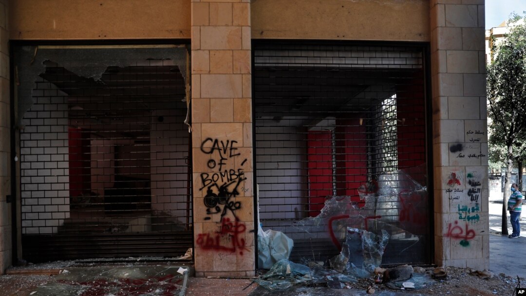 A man looks at shops damaged during an anti-government protest in Beirut, Lebanon, June 12, 2020.