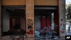A man looks at shops damaged during an anti-government protest in Beirut, Lebanon, June 12, 2020.