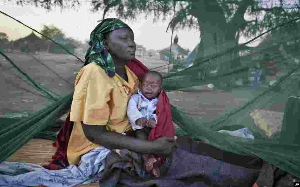 A displaced mother and her baby, one of the few to have a mosquito net, wake up at a refugee camp, Awerial, South Sudan, Jan. 2, 2014.