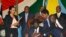FILE - S. Sudan President Salva Kiir, seated, signs a peace deal as Kenya’s President Uhuru Kenyatta, center-left, Ethiopia’s Prime Minister Hailemariam Desalegn, center-right, and Uganda’s President Yoweri Museveni, right, look on in Juba, S. Sudan, Aug. 26, 2015.