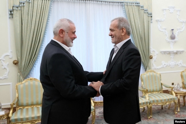 Iranian President Masoud Pezeshkian, right, meets with Palestinian group Hamas' top leader, Ismail Haniyeh, in Tehran, July 30, 2024.