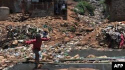 FILE - A young resident plays in Nairobi's Kibera slum, one of Africa's largest slums, Sept. 19, 2018. 