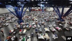 FILE - Evacuees escaping the floodwaters from Tropical Storm Harvey rest at the George R. Brown Convention Center that has been set up as a shelter in Houston, Texas, Aug. 29, 2017.