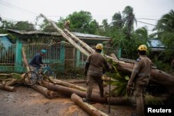 Petugas membersihkan jalan dari pohon tumbang akibat hantaman Badai Julia, di Bluefields, Nikaragua 9 Oktober 2022. REUTERS/Maynor Valenzuela