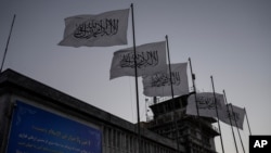 FILE - Taliban flags flutter at the airport in Kabul, Afghanistan, Sept. 9, 2021.