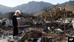 Marsha Maus, who has lived in the Seminole Springs Mobile Home Park for 15 years, looks through her charred belongings, NSunday,