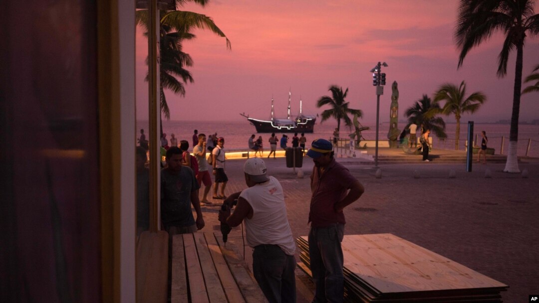 Warga mengantisipasi Badai Patricia dan memasang perlindungan untuk jendela di kawasan bisnis di tepi pantai kota Puerto Vallarta, Meksiko, Kamis, 22 Oktober 2015. (AP Photo/Cesar Rodriguez)