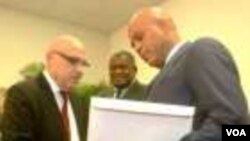 Prezidan Martelly ap resevwa rapò a nan men kowòdonatè komisyon an, Doktè Réginald Boulos (Foto: HPN/Clarens Renois).
