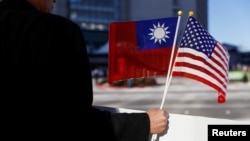 Seorang demonstran memegang bendera Taiwan dan AS untuk mendukung Presiden Taiwan Tsai Ing-wen yang transit di wilayah AS dalam lawatan ke Amerika Latin di Burlingame, California, 14 Januari 2017.