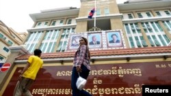 People walk in front of the Phnom Penh Municipal Court before a verdict against six union leaders, in Phnom Penh, Cambodia, Dec. 11, 2018. 