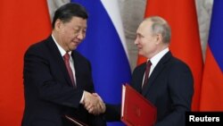 Presiden Rusia Vladimir Putin berjabat tangan dengan tamunya, Presiden China Xi Jinping, selama upacara penandatanganan setelah pembicaraan hari kedua mereka di Kremlin, Selasa 21 Maret 2023.