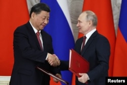2023年3月21日俄罗斯总统普京与中国国家主席习近平在会谈后举行的签字仪式上握手