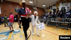 John Goodie (L) accompanies supporter Jerry Emmett before a campaign rally by U.S. Democratic presidential candidate Hillary Clinton at Carl Hayden Community High School in Phoenix, Arizona, March 21, 2016.