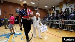 John Goodie (L) accompanies supporter Jerry Emmett before a campaign rally by U.S. Democratic presidential candidate Hillary Clinton at Carl Hayden Community High School in Phoenix, Arizona, March 21, 2016.