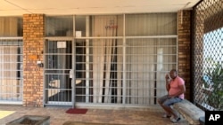 A man sits outside the closed Isizinda Sempilo clinic in the Johannesburg township of Soweto Thursday, Jan. 30, 2025. (AP Photo/Alfonso Nqunjana)