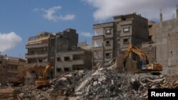 FILE - Bulldozers remove the debris of damaged buildings impacted by fatal floods in Derna, Libya, September 30, 2023. 