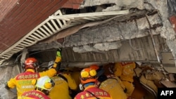 台湾消防人员2024年4月3日在花莲一处倒塌建筑物中寻找地震生还者。