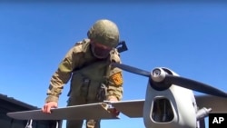 FILE - This handout photo taken from video released by Russian Defense Ministry Press Service on Aug. 8, 2022, shows a Russian serviceman preparing a reconnaissance drone. Russia shot down drones over Belgorod and the Black Sea, while Ukraine shot down a reconnaissance drone.
