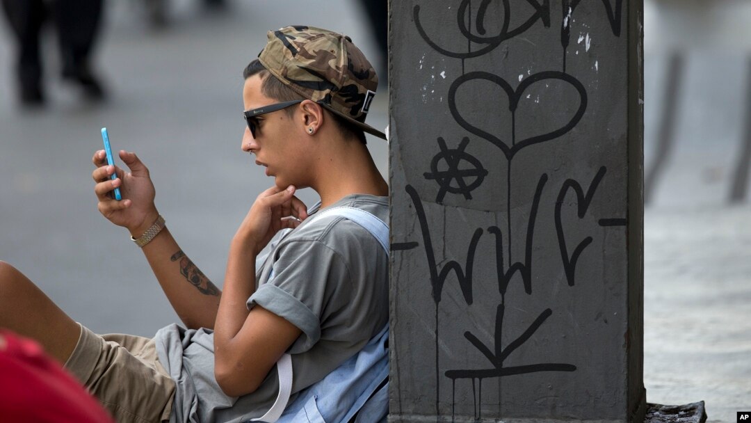 FILE - A young man checks his cell phone in Sao Paulo, Brazil, Dec. 17, 2015. A judicial order issued earlier this week left 100 million Brazilians without access to the popular WhatsApp messaging platform for 72 hours.