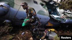 A Uganda People's Defence Air Force (UPAF) crewman walks next to a Somalia-bound Ugandan Mi-24 attack helicopter that crashed at Mount Kenya, August 13, 2012. 