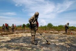 FILE - Soldiers detect Unexploded Ordnance and defoliant Agent Orange during the launch of the "environmental remediation of dioxin contamination" project, in Da Nang City, Vietnam.