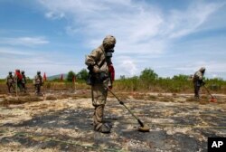 FILE - Soldiers detect Unexploded Ordnance and defoliant Agent Orange during the launch of the "environmental remediation of dioxin contamination" project, in Da Nang City, Vietnam.