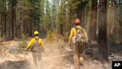 FILE - Firefighters search for hot spots on the northeast side of the Bootleg Fire, near Sprague River, Ore., July 14, 2021.