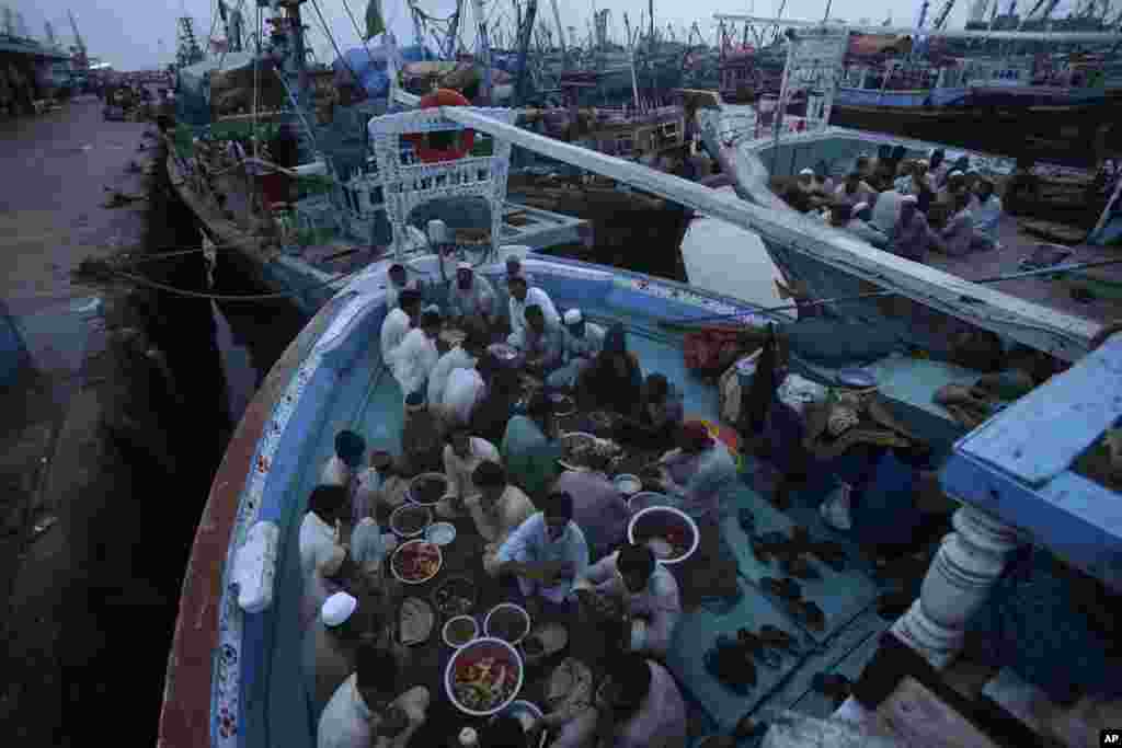 کراچی کے ایک ساحلی علاقے پر لنگر انداز کشتی میں روزے دار ماہی گیر افطار کے منتظر ہیں۔