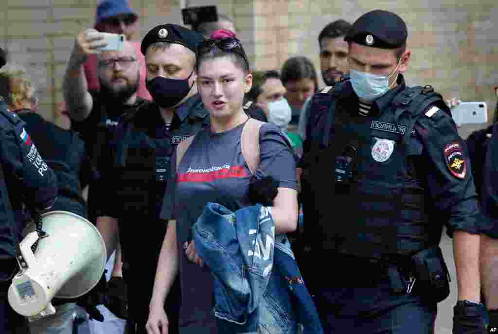 Police detain RT Television channel journalist Maria Sherstyukova during a rally to support Ivan Safronov near the Lefortovo prison in Moscow, Russia. Safronov, a former military journalist, was arrested and charged with treason.