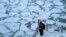 A pedestrian stops to take a photo by Chicago River, as bitter cold phenomenon called the polar vortex has descended on much of the central and eastern United States, in Chicago, Illinois, U.S., January 29, 2019.