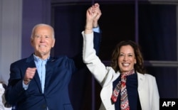 Presiden AS Joe Biden (Kiri) dan Wakil Presiden AS Kamala Harris berpegangan tangan dan memberi isyarat saat mereka menyaksikan pertunjukan kembang api Hari Kemerdekaan dari Balkon Truman Gedung Putih di Washington, DC, pada 4 Juli 2024. (Foto: AFP)