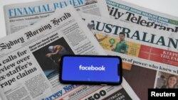 Ảnh minh họa - màn ảnh điện thoại di động với logo "Facebook" logo và báo chí Úc ở thủ đô Canberra, Úc châu, ngày 18/2/2021. (Reuters)