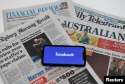 Logo Facebook tampak di sebuah layar ponsel dengan latar sejumlah koran Australia di Canberra, Australia, 18 Februari 2021. (Foto: Reuters)