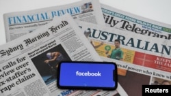 FILE - An illustration shows a phone screen with the Facebook logo and Australian newspapers in Canberra, Australia, Feb. 18, 2021. 
