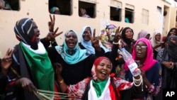 FILE - Sudanese pro-democracy supporters celebrate a final power-sharing agreement with the ruling military council, in Khartoum, Aug. 17, 2019. For the first time in three decades, Sudan has charted a path out of military rule.