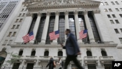 FILE - People walk by the New York Stock Exchange, June 24, 2016.