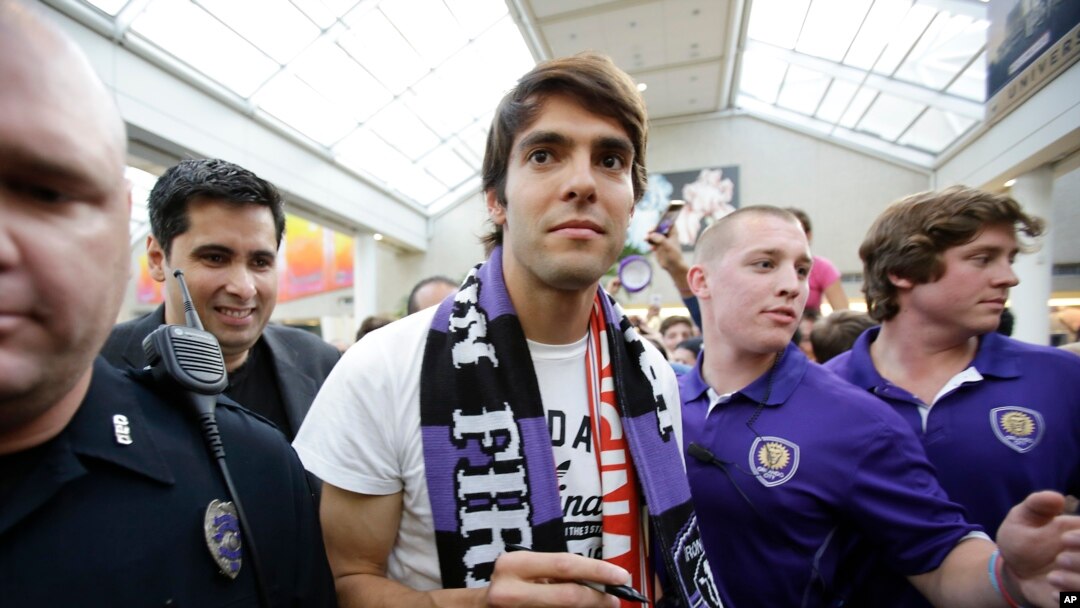 La estrella del fútbol brasileño Kaká (centro), llega al aeropuerto de Orlando, Florida, rodeado por agentes de seguridad.