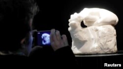 A visitor looks at "Andromede," a marble by French sculptor Auguste Rodin (1840-1917) displayed at the auction house Artcurial in Paris, France, March 17, 2017. 
