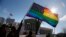 FILE - Gay rights activists wave rainbow flag in front of the U.S. Supreme Court in Washington.