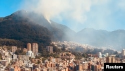 El humo se eleva desde un incendio forestal en una colina en Bogotá, Colombia, el 24 de enero de 2024, en esta captura de pantalla obtenida de un video de las redes sociales.