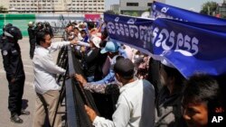 Cambodia land and forest activists stand at a blocked street near the National Assembly, in Phnom Penh, Cambodia, Thursday, May 29, 2014. 